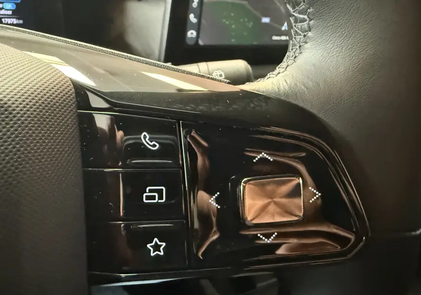 Gros plan sur les commandes noires du volant côté gauche du MG3 Luxury, avec boutons tactiles et finition brillante.