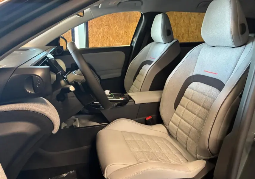 Vue intérieure côté conducteur du Citroën C5 Aircross 2026, sièges gris clair avec détails noirs et rouges.
