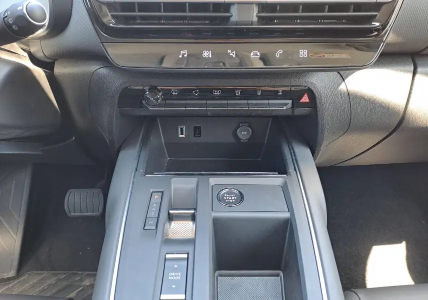 Vue rapprochée de la console centrale noire du Citroën C5 Aircross hybride 2024 avec commandes de boîte auto et bouton start-stop.