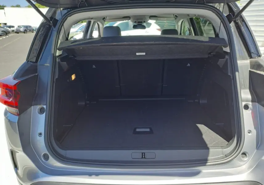 Coffre ouvert vu de l'arrière d'un Citroën C5 Aircross gris Artense avec toit noir, montrant un espace de chargement vide.