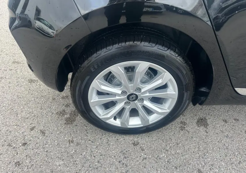 Gros plan sur la roue avant droite noire d'une Renault Clio V dCi 100 Evolution avec jante argentée moderne.