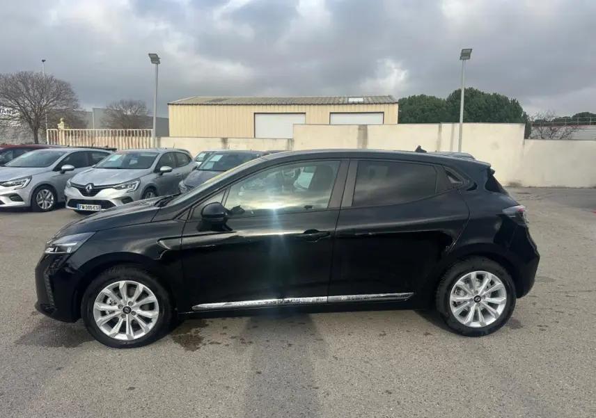 Renault Clio V dCi 100 Evolution noire vue de profil côté gauche, vitres surteintées et jantes argentées visibles.