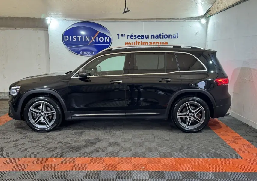 Vue de profil côté gauche d’un Mercedes GLB 200 d AMG Line noir avec jantes alliage et rails de toit chromés.