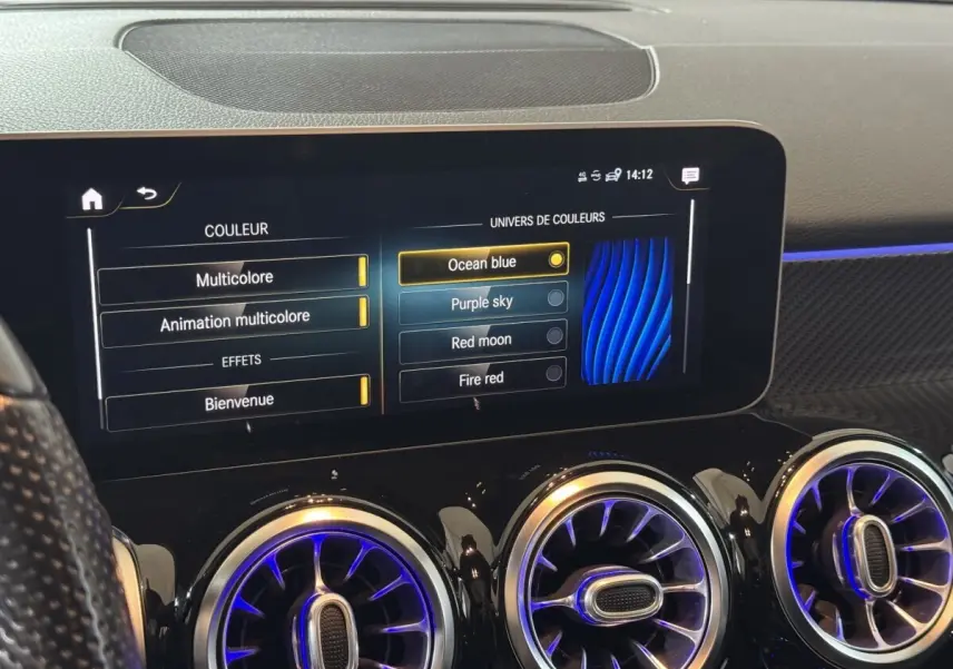 Détail de l’écran tactile central et des aérateurs ronds avec éclairage bleu intérieur du tableau de bord Mercedes GLB 200 d AMG Line.