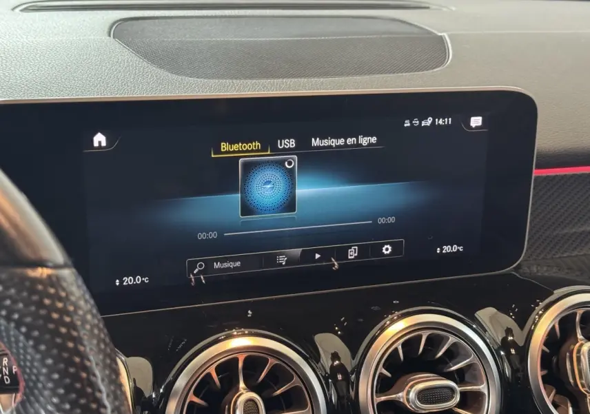 Vue rapprochée de l’écran tactile multimédia et des aérateurs ronds noirs du tableau de bord d’un Mercedes GLB 200 d AMG Line.