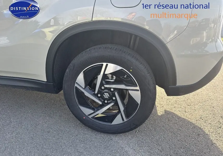 Gros plan sur la roue arrière droite d’un Suzuki Vitara ivoire So'Color avec jante alu bicolore noire et argent.
