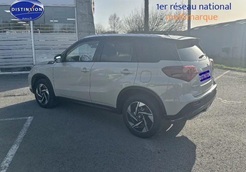 Suzuki Vitara 2026 So'Color Savanna Ivory/Black métal, vue 3/4 arrière côté gauche avec jantes alu distinctives.