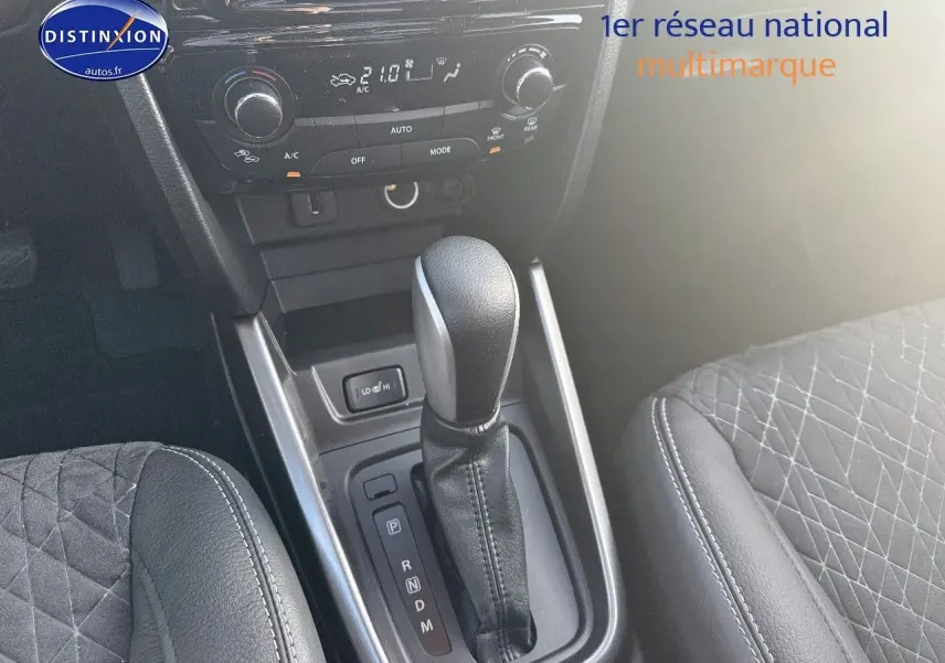 Vue rapprochée de la console centrale du Suzuki Vitara 2026, levier de boîte auto et sièges en suédine noire.