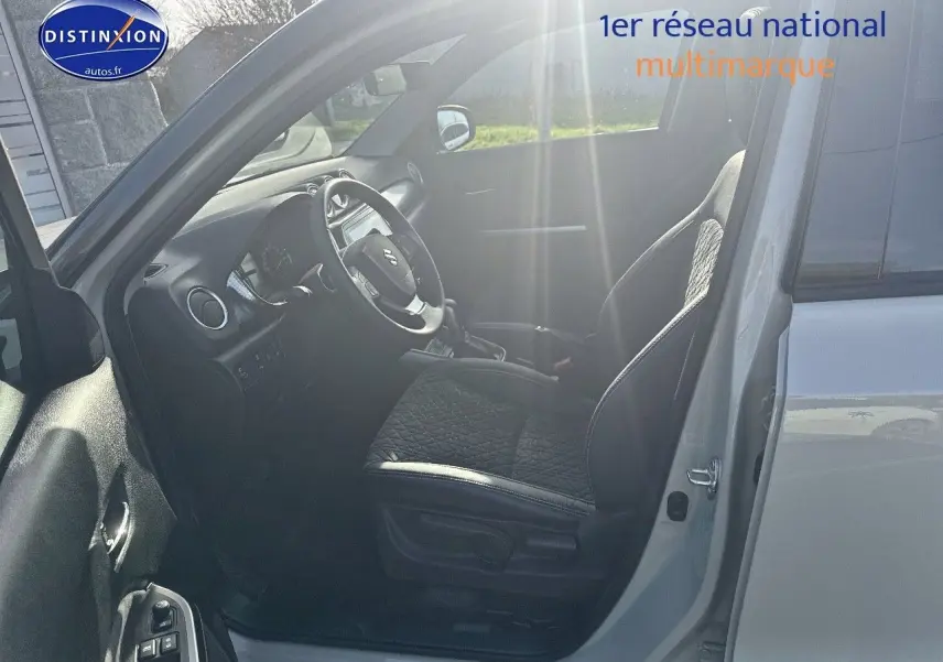 Intérieur côté conducteur du Suzuki Vitara 2026 en So'Color Savanna Ivory, sièges cuir noir et volant multifonction.