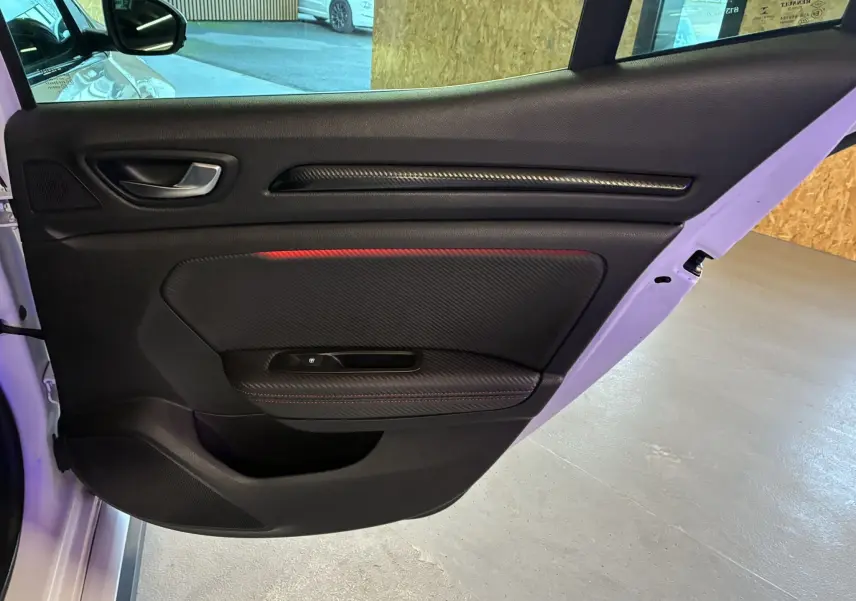 Vue intérieure de la porte arrière droite noire avec surpiqûres rouges de la Renault Mégane IV RS 280 blanche de 2018.