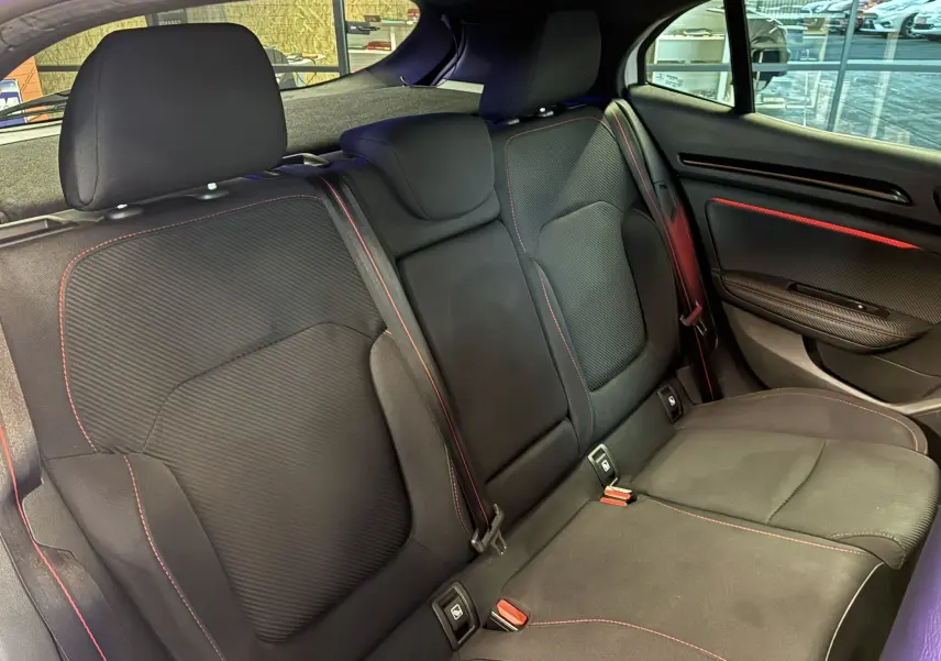 Vue intérieure côté droit des sièges arrière noirs avec surpiqûres rouges de la Renault Mégane IV RS 280 EDC6 blanche de 2018.