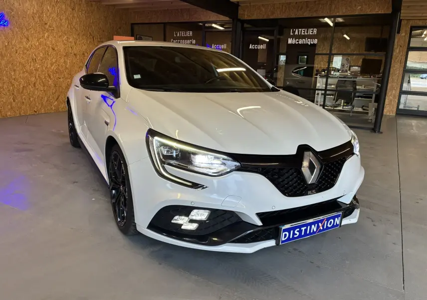 Renault Mégane IV RS 280 EDC6 blanche vue 3/4 avant droit, avec calandre noire et jantes noires sport.