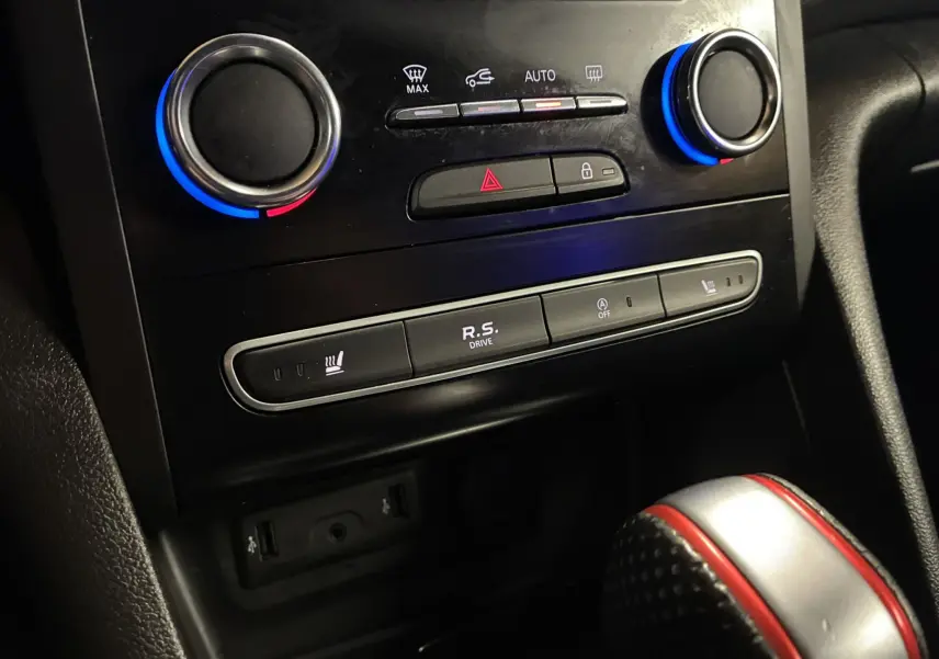 Gros plan sur la console centrale de la Renault Mégane IV RS 280 blanche, avec commandes climatisation et bouton R.S. Drive.