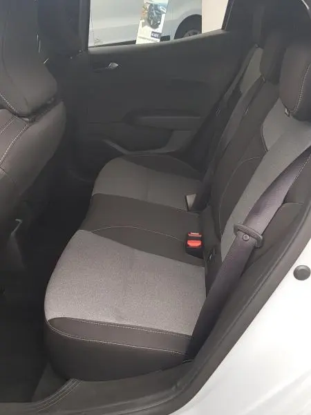 Vue latérale intérieure du siège arrière droit de la Renault Clio gris 2025, montrant les ceintures et le tissu bicolore des sièges.