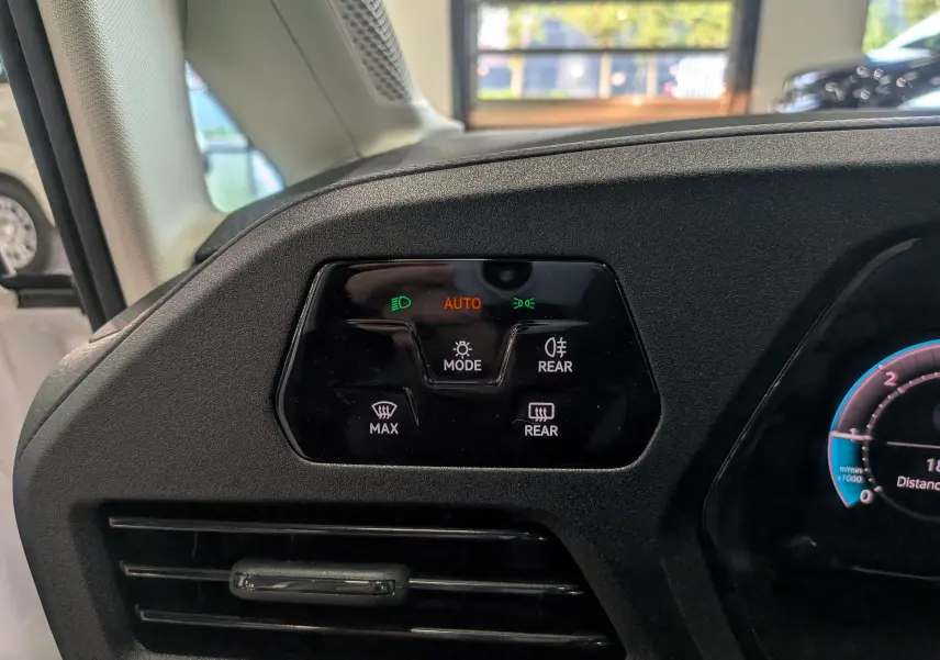 Gros plan sur le tableau de bord du Volkswagen Caddy 2.0 TDI 2025, montrant les commandes d’éclairage et de désembuage.