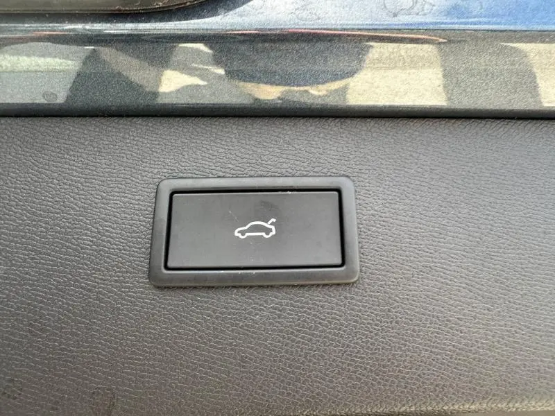 Bouton noir d'ouverture électrique du coffre sur tableau de bord de CUPRA Formentor gris Magnétique métallisé.