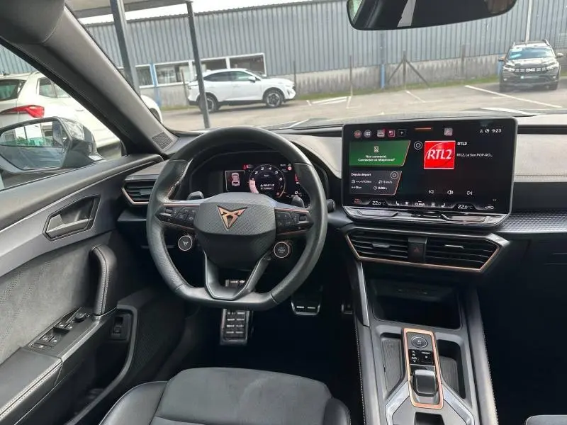 Vue intérieure avant du CUPRA Formentor 1.5 eTSI Hybrid 2025, volant cuir multifonction et grand écran tactile central.