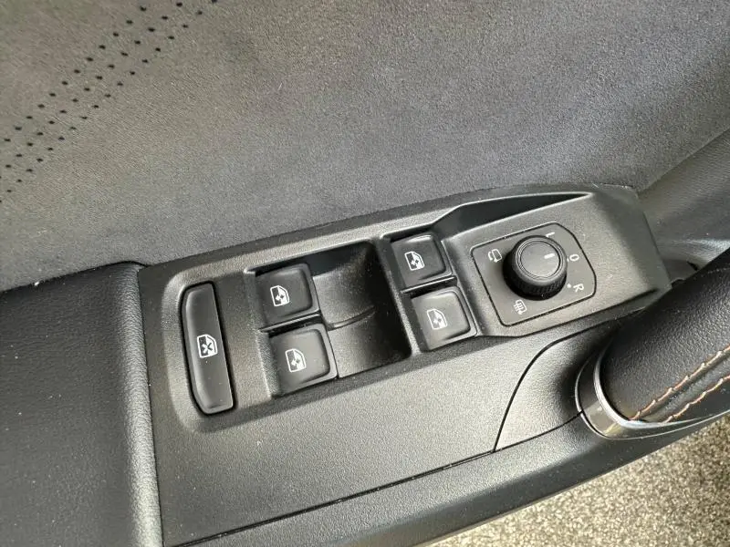 Gros plan sur les commandes de lève-vitres et réglage des rétroviseurs côté conducteur d'une CUPRA Formentor gris métallisé.