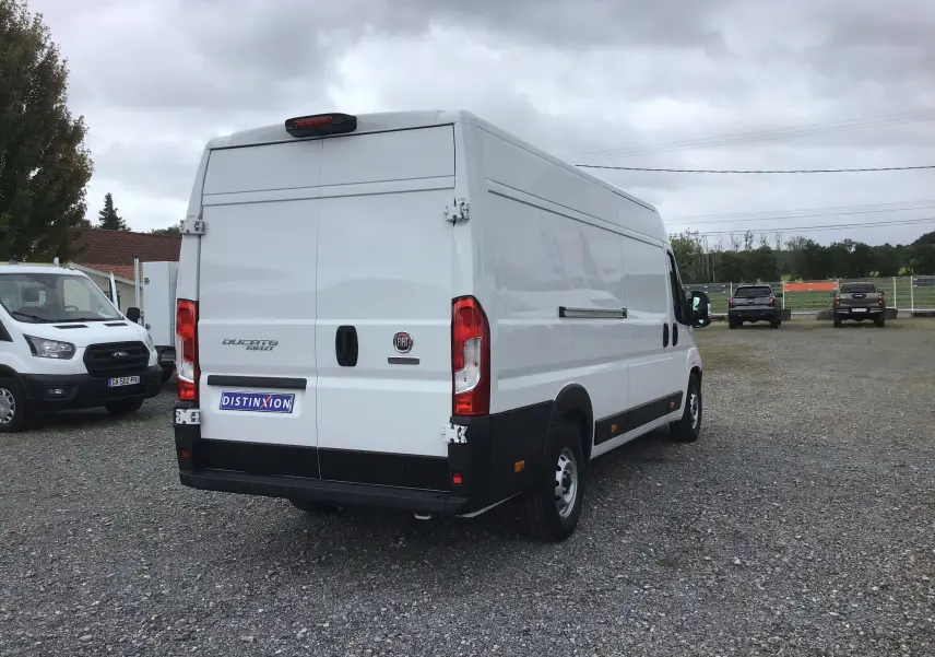 Vue arrière d'un FIAT Ducato Fourgon blanc XLH2 3T5 avec portes battantes et feux rouges visibles.