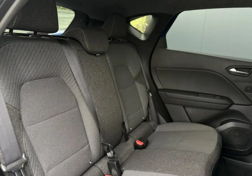 Vue intérieure côté droit des sièges arrière gris foncé du Renault Captur 2025 avec ceinture de sécurité et garnitures de porte.