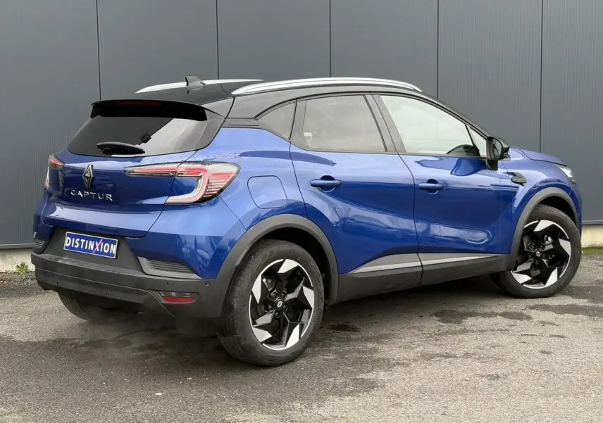 Vue 3/4 arrière droite du Renault Captur 2025 bleu Iron avec toit noir, jantes alu 18 pouces diamantées noires et railing de toit alu.