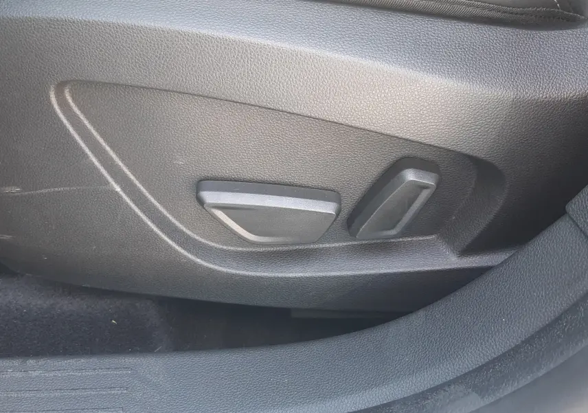 Détail des commandes de réglage électrique du siège en cuir noir du Renault Symbioz gris Cassiopée.