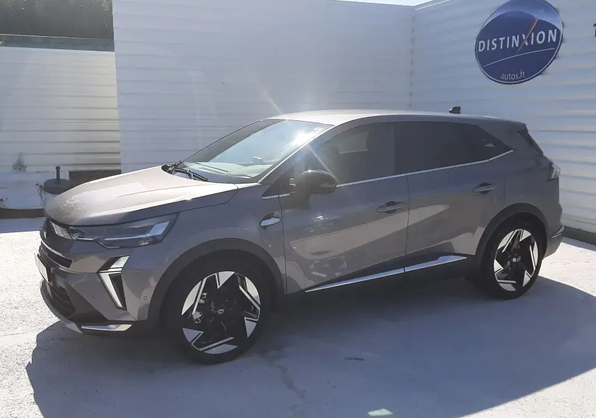 Renault Symbioz gris cassiopée en vue 3/4 avant droit, avec jantes noires et détails modernes sous un ciel clair.