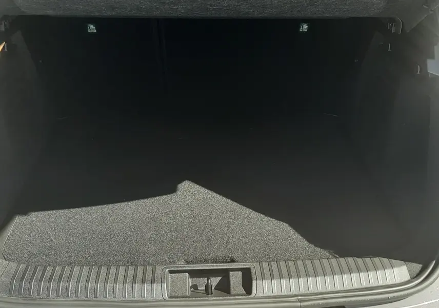 Coffre ouvert vu de l'arrière d'une Renault Symbioz gris Cassiopée, montrant un espace de chargement vide et propre.
