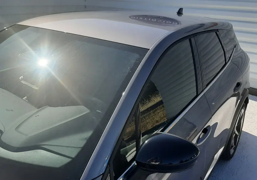 Vue 3/4 avant droit d'une Renault SYMBIOZ gris cassiopée avec rétroviseur noir et toit clair.