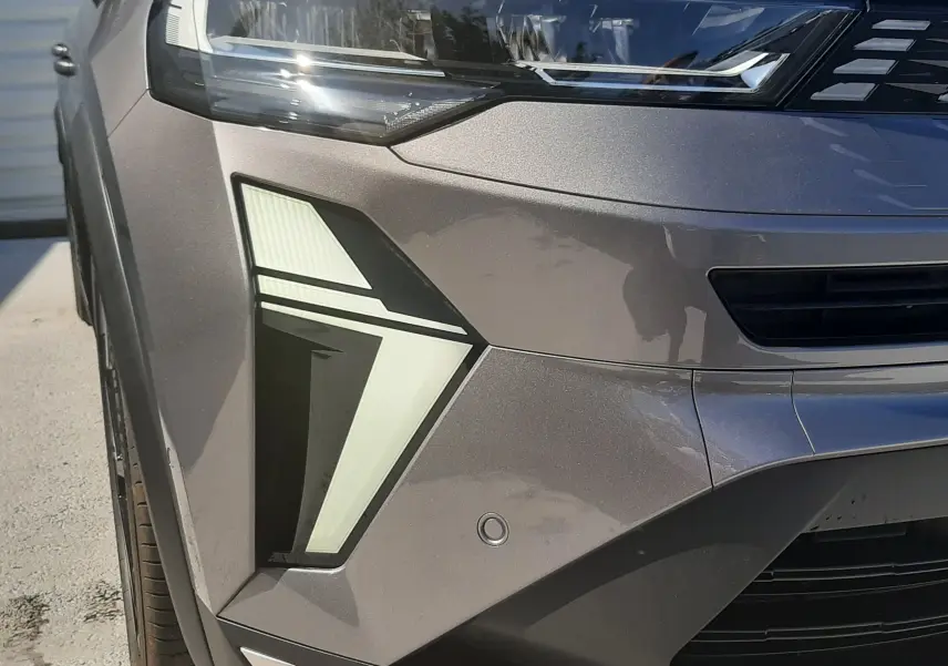 Gros plan sur le phare avant gauche du Renault Symbioz gris Cassiopée avec feux LED au design angulaire.