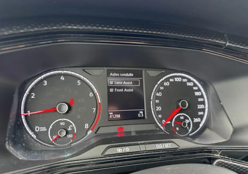 Tableau de bord numérique du Volkswagen T-cross 1.0 TSI 110 Active affichant les aides à la conduite Lane Assist et Front Assist.