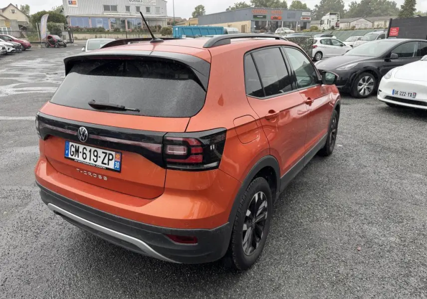 Volkswagen T-Cross orange métallisé vue 3/4 arrière droit, avec feux arrière noirs et jantes alliage Galway.
