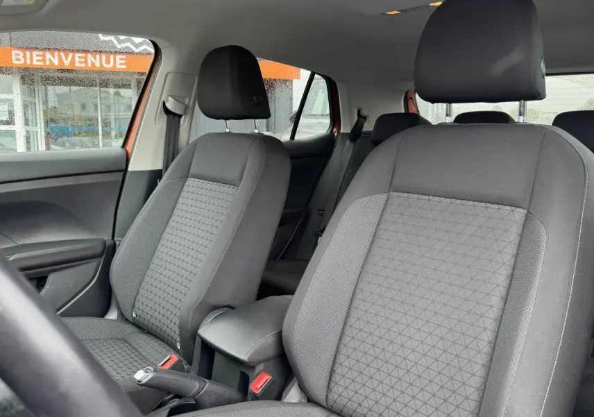 Gros plan sur les sièges avant en tissu gris du Volkswagen T-Cross 1.0 TSI 110 Active, vue intérieure côté gauche.