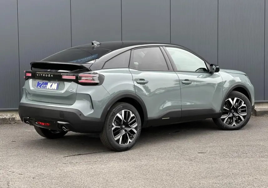 Vue 3/4 arrière droite d'une Citroën C4 Manhattan Green avec toit noir et jantes alliage 18 pouces.