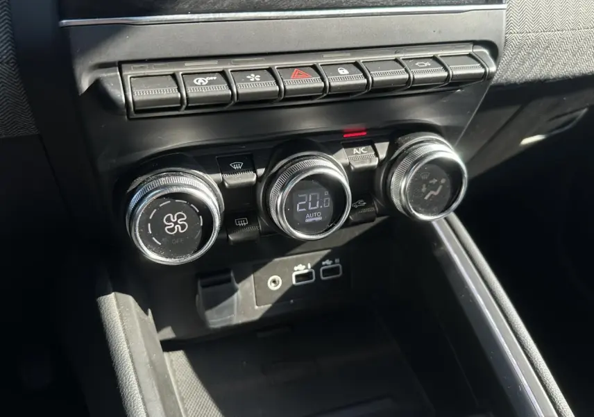 Gros plan sur les commandes de climatisation et boutons multifonctions du tableau de bord de la Renault Clio TCE 90 Techno.