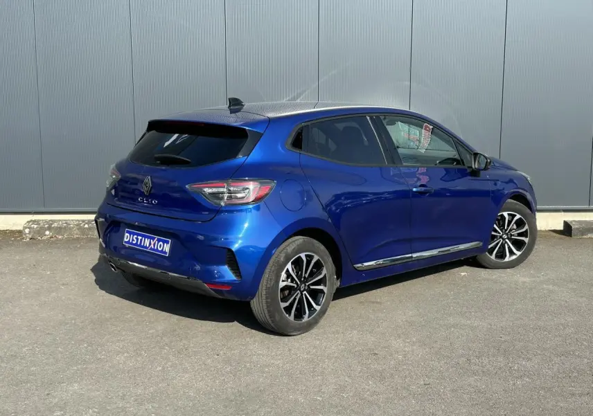 Vue 3/4 arrière droite d'une Renault Clio Bleu Iron 2025 avec jantes alliage et vitres surteintées.
