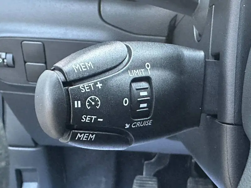 Gros plan sur la commande de régulateur de vitesse du Citroën C3 1.2 PureTech 2023, intérieur noir.