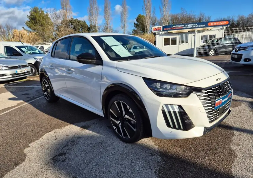 Peugeot 208 Hybrid blanc vue 3/4 avant droit, avec jantes alliage noires et calandre distinctive GT.