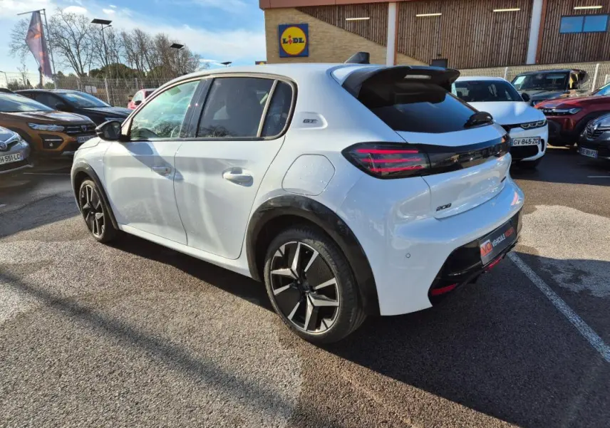 Peugeot 208 Hybrid blanc vue 3/4 arrière droit, jantes alliage 17 pouces et toit avec antenne requin.