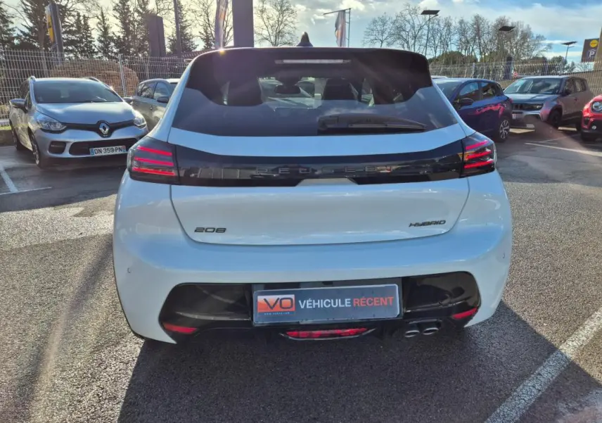 Vue arrière d'une Peugeot 208 Hybrid blanche de 2025 avec feux arrière LED et double sortie d'échappement.