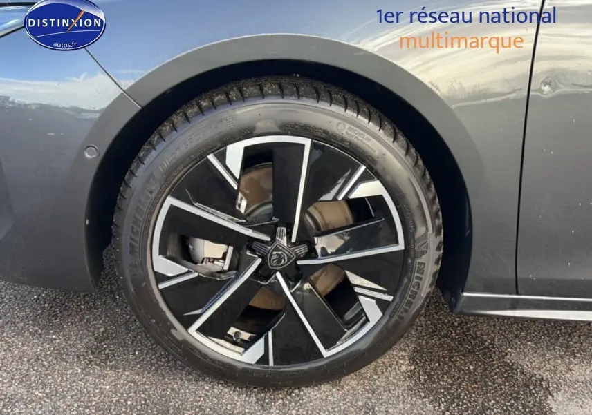 Gros plan sur la jante alu noire et argentée du côté gauche d'une Peugeot 508 Hybrid gris titane 2024.