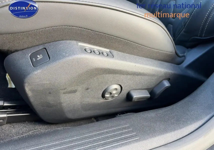 Gros plan sur les commandes de réglage électrique du siège avant droit en cuir noir du Peugeot 508 Hybrid 225 GT e-EAT8 gris titane.