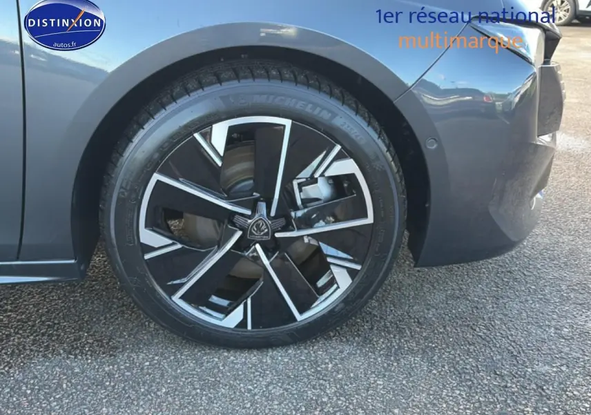 Gros plan sur la roue avant gauche de la Peugeot 508 Hybrid 225 GT e-EAT8 gris titane avec jante alu noire et argent.