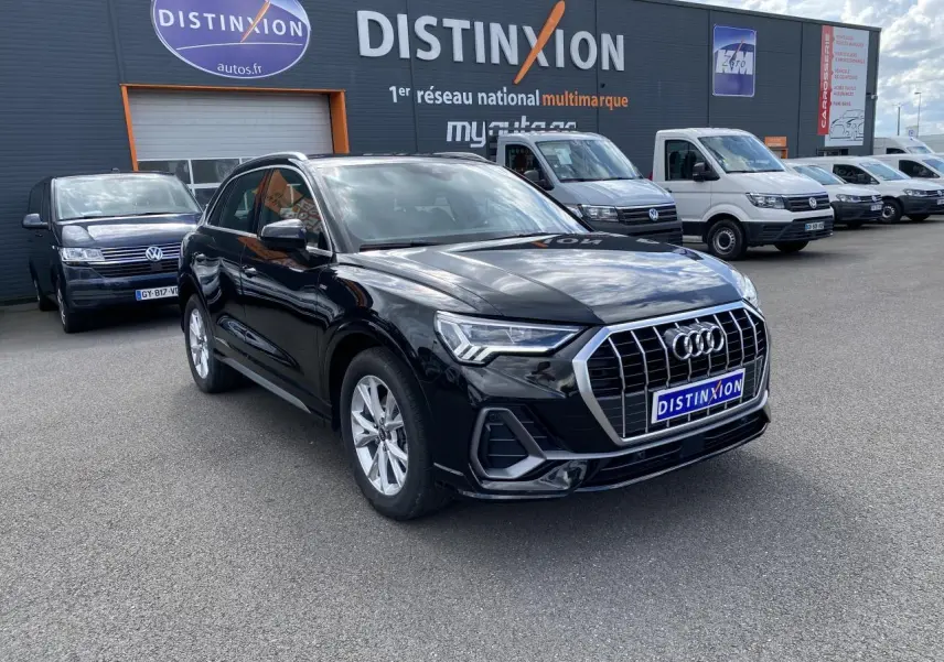 Audi Q3 noir intense métallisé vue 3/4 avant droit avec calandre chromée et jantes aluminium devant concession multimarque