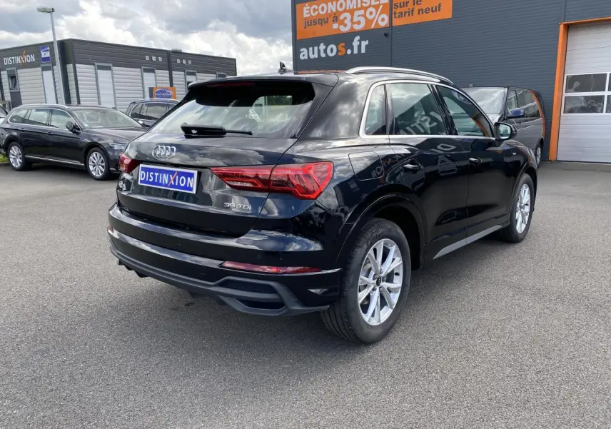 Audi Q3 noir intense métallisé vue 3/4 arrière droit, avec jantes argentées et logo 35 TDI visible sur le hayon.