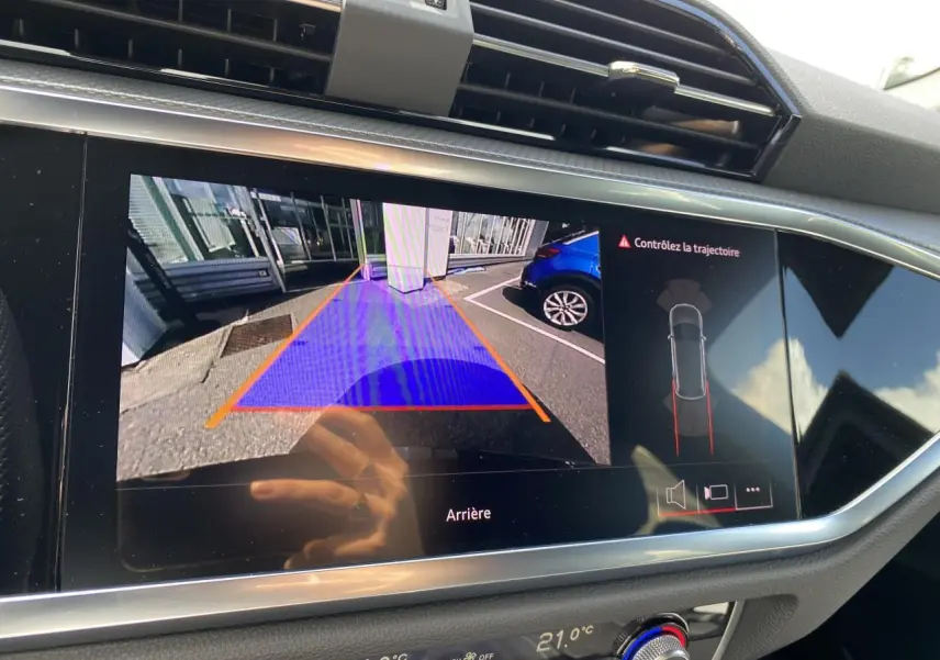 Écran central affichant la caméra de recul avec guidage, dans l'habitacle d'un Audi Q3 noir intense métallisé.