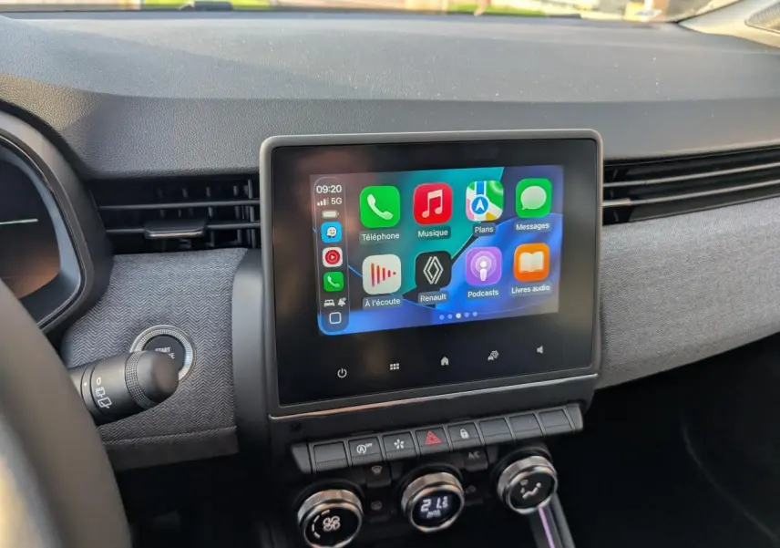 Écran tactile central avec interface multimédia Apple CarPlay dans le tableau de bord gris de la Renault Clio 2025.