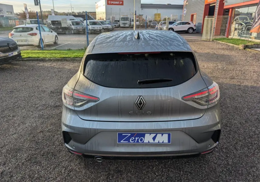Vue arrière d'une Renault Clio gris schiste 2025 avec feux LED en forme de C et sortie d'échappement chromée visible.
