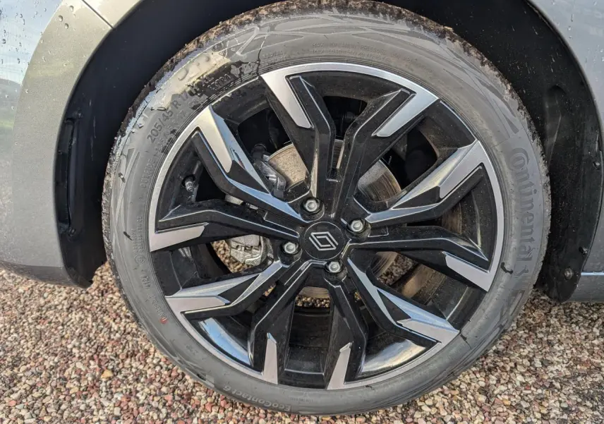 Gros plan sur la jante alliage noir monastella 17 pouces de la Renault Clio gris schiste 2025 avec logo Renault central.