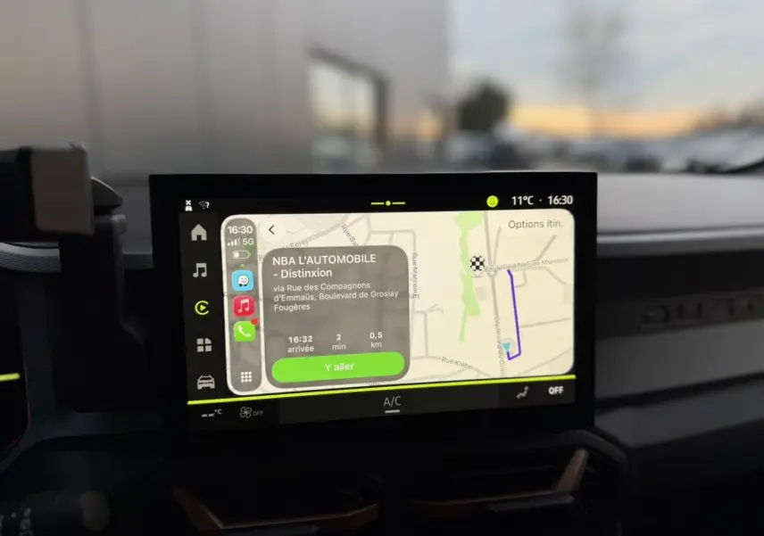 Écran tactile central du Dacia Duster 2025 affichant la navigation avec carte et itinéraire en cours.